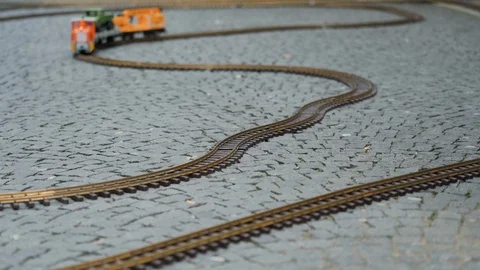 Multi colored model of freight train travels along the winding rails of the 库存影片 115959322