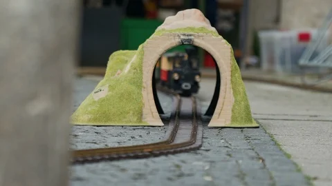 Multi-colored model of locomotive moves through the yellow toy arch or tunnel 스톡 동영상 115958272