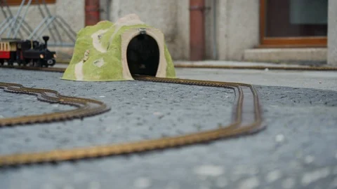 Multi-colored model of locomotive moves through the yellow toy arch or tunnel 스톡 동영상 115961729