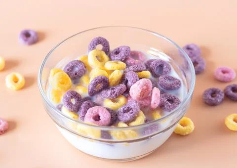 Multi-colored multi-slag breakfast cereal rings with milk in a glass bowl Stock Photos