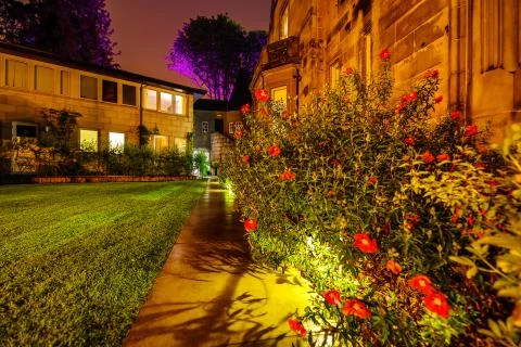 Multi-colored night lighting of the Scottish house garden. Stock Photos