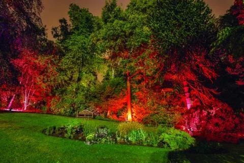 Multi-colored night lighting of the Scottish house garden. Stock Photos
