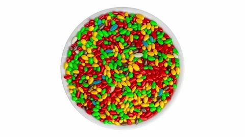 Multi-colored oval candies are scattered on a round plate 스톡 동영상 242357725