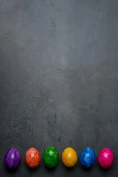 Multi-colored painted Easter eggs on a dark stone background Stock Photos