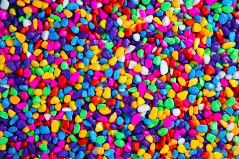 Multi-colored painted sea pebbles. Bright background. Stock Photos