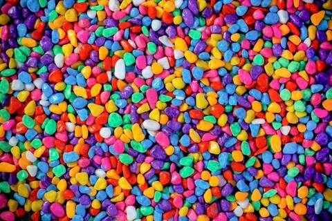 Multi-colored painted sea pebbles. Bright background. Stock Photos