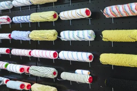 Multi-colored painter roller  for repairing black wall painting hang on a sta Foto stock