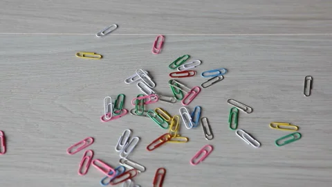 Multi-colored paper clips fall on the table.fastening for paper. Stock Footage 156870993