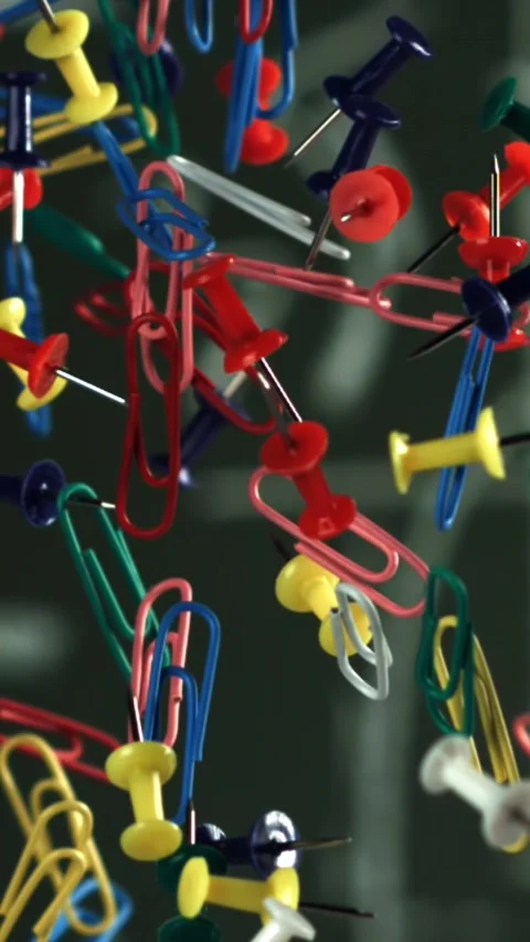 Multi-colored paper clips fly up and fall down. Filmed on a high-speed camera at Stock Footage 335370409