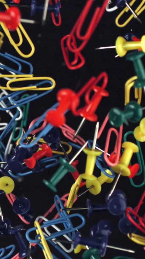 Multi-colored paper clips fly up and fall down. Filmed on a high-speed camera at Stock Footage 335381104