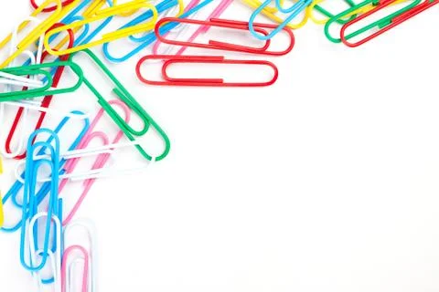 Multi-colored paper clips on a white paper Stock Photos