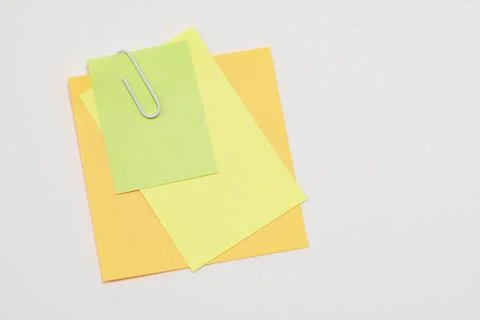 Multi-colored paper notes fastened with a paper clip on a white background. Stock-Fotos