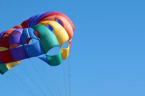Multi-colored parachute against the background of the sunny sky, copy space Stock Photos