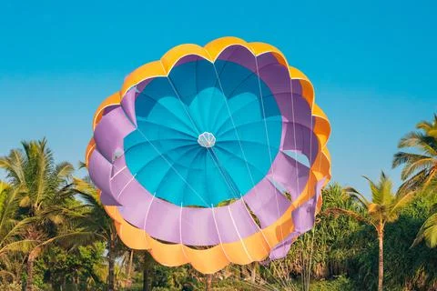 Multi-colored Parachute For Parasailing On Background Of Palm Trees And Blue Sky Fotos de archivo
