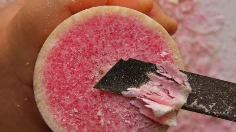 A multi-colored paraffin candle is cut into small pieces with a stationery knife Stock Footage 244749953