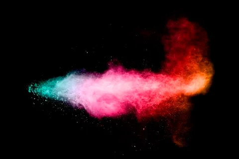Multi colored particles explosion on black background.Colorful dust splash. Stock Photos