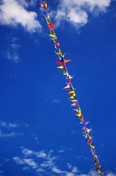 Multi colored party flags on a line on a background of blue sky Stock Photos