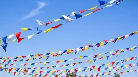 Multi colored party rainbow flags on blue sky for celebration. Flags Color... Stock Photos