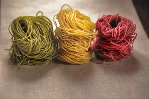 Multi-colored pasta nests, on baking paper, red, yellow and green colors Stock Photos