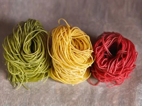 Multi-colored pasta nests, on baking paper, red, yellow and green colors Stock Photos