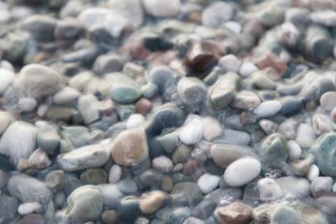 Multi-colored pebbles on the beach, washed by waves Foto stock