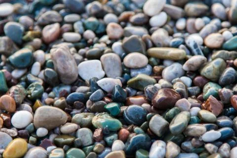 Multi-colored pebbles on the beach, washed by waves Foto stock