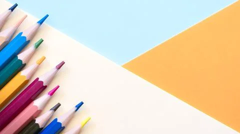 Multi colored pencils on empty sheet, Pastel colored blue, peach and orange Stock Photos