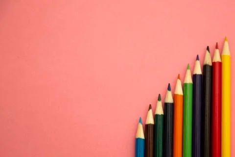 Multi-colored pencils on a pink background. Stock Photos