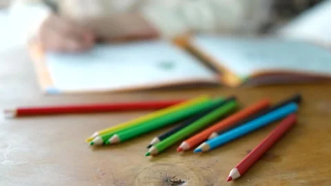 Multi-colored pencils on the table near the notebook Stock Footage 296446088