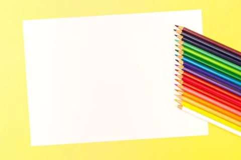 Multi-colored pencils on a yellow background. Top view. Copy space. Stock Photos