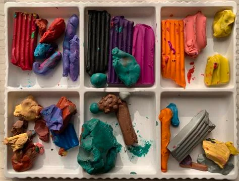 Multi-colored pieces of plasticine in a box. Material for the development of  Stock Photos