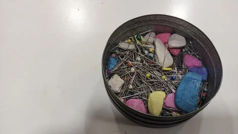 Multi-colored pieces of soap, chalk and needles are in a tin can in a tailoring Foto stock