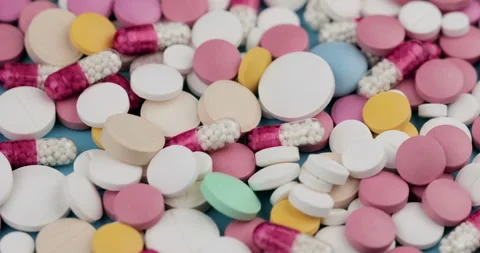 Multi-colored pills and capsules of different sizes and shapes rotate Stock Footage 149148205