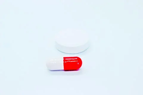 Multi-colored pills are located on a white background Stock Photos