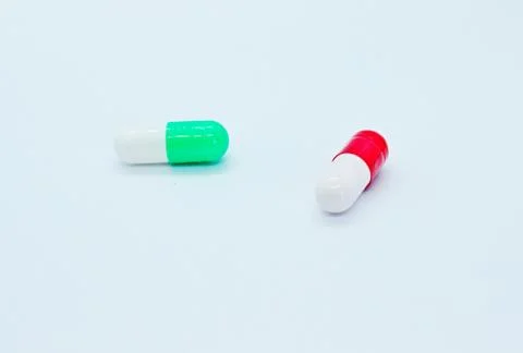 Multi-colored pills are located on a white background Stock Photos