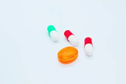 Multi-colored pills are located on a white background Stock Photos
