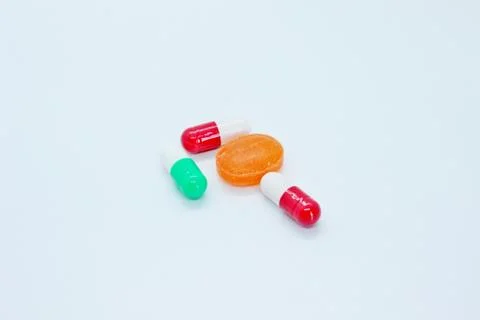 Multi-colored pills are located on a white background Stock Photos