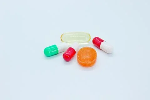 Multi-colored pills are located on a white background Stock Photos