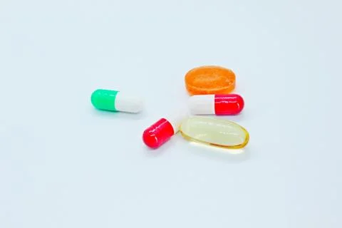 Multi-colored pills are located on a white background Stock Photos