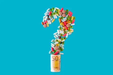 Multi-colored pills in the form of a question mark, with euro banknotes. Stock Photos