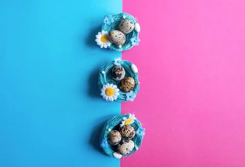 Multi-colored pink and blue background with quail eggs in a basket. Easter ca Stock Photos