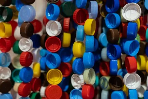 Multi-colored plastic caps hang in a row on a thread to form a beautiful Stock Photos