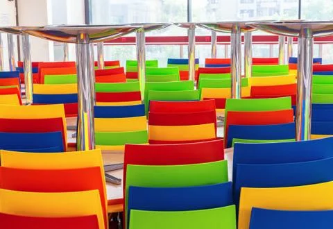 Multi-colored plastic chairs and tables in a closed cafe. Stock Photos