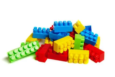 Multi-colored plastic designer building blocks on a white background. Colorfu Stock Photos