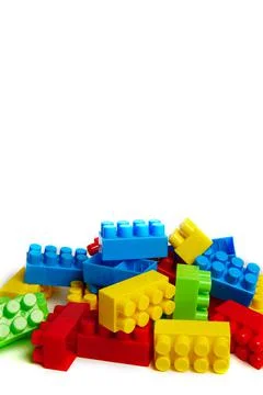 Multi-colored plastic designer building blocks on a white background. Colorfu Stock Photos