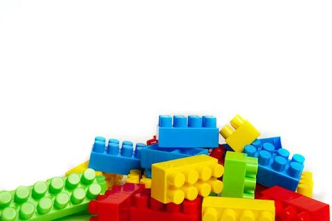 Multi-colored plastic designer building blocks on a white background. Colorfu Stock Photos