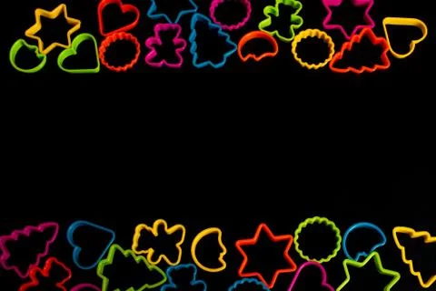 Multi-colored plastic molds of various shapes grouped on top and bottom for m Stock Photos