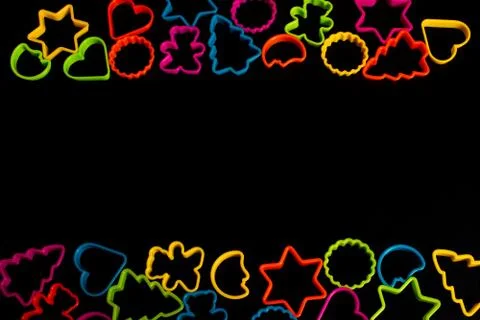 Multi-colored plastic molds of various shapes grouped on top and bottom for m Stock-Fotos