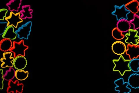 Multi-colored plastic molds of various shapes grouped on the right and left f Stock Photos