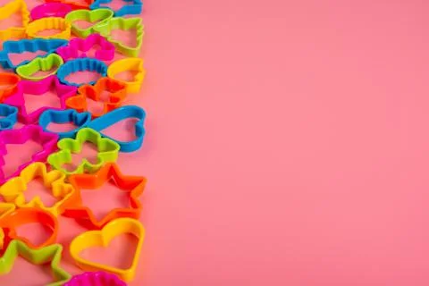Multi-colored plastic molds of various shapes grouped on the left for making  Stock Photos